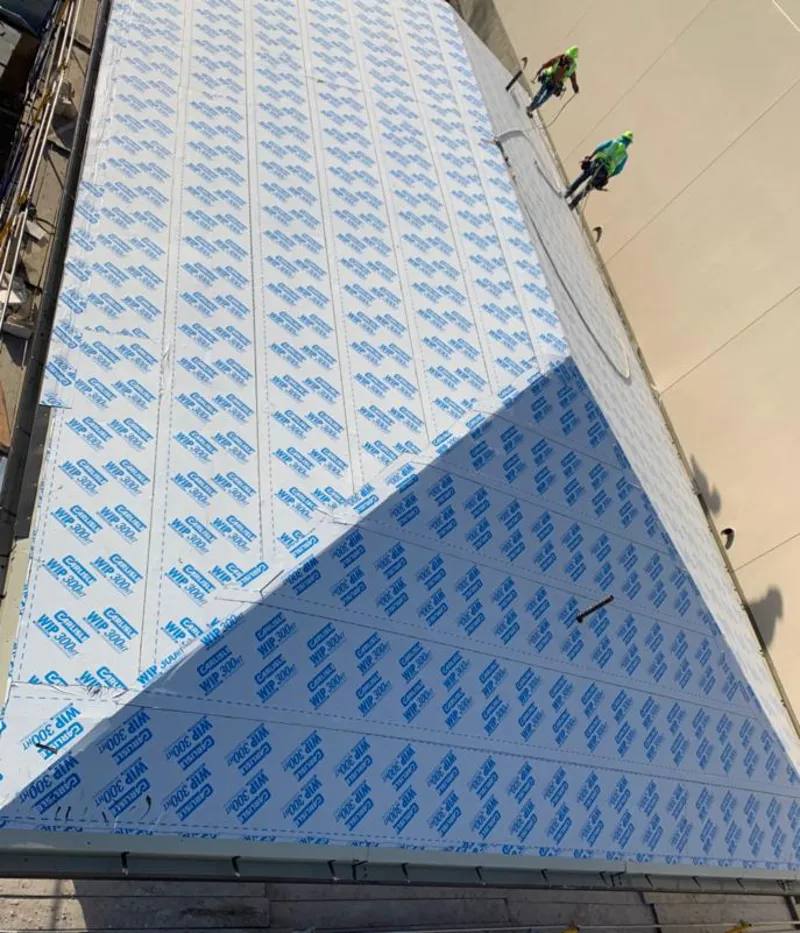 Professional roofers installing underlayment on a metal roof in Ojai